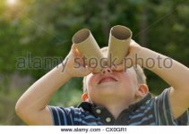 young-boy-looking-through-empty-toilet-paper-rolls-cx0gr1.jpg